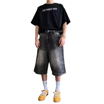 Man wearing loose light blue washed denim shorts with a straight leg and cropped length.