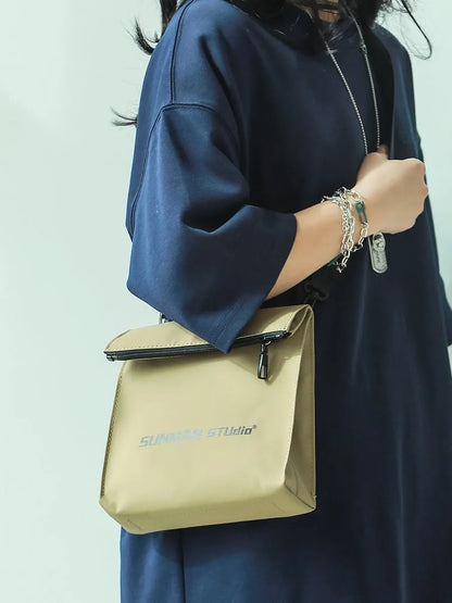 Polyester Oxford fabric messenger-style backpack in khaki colour with visible stitching and a crossbody strap.