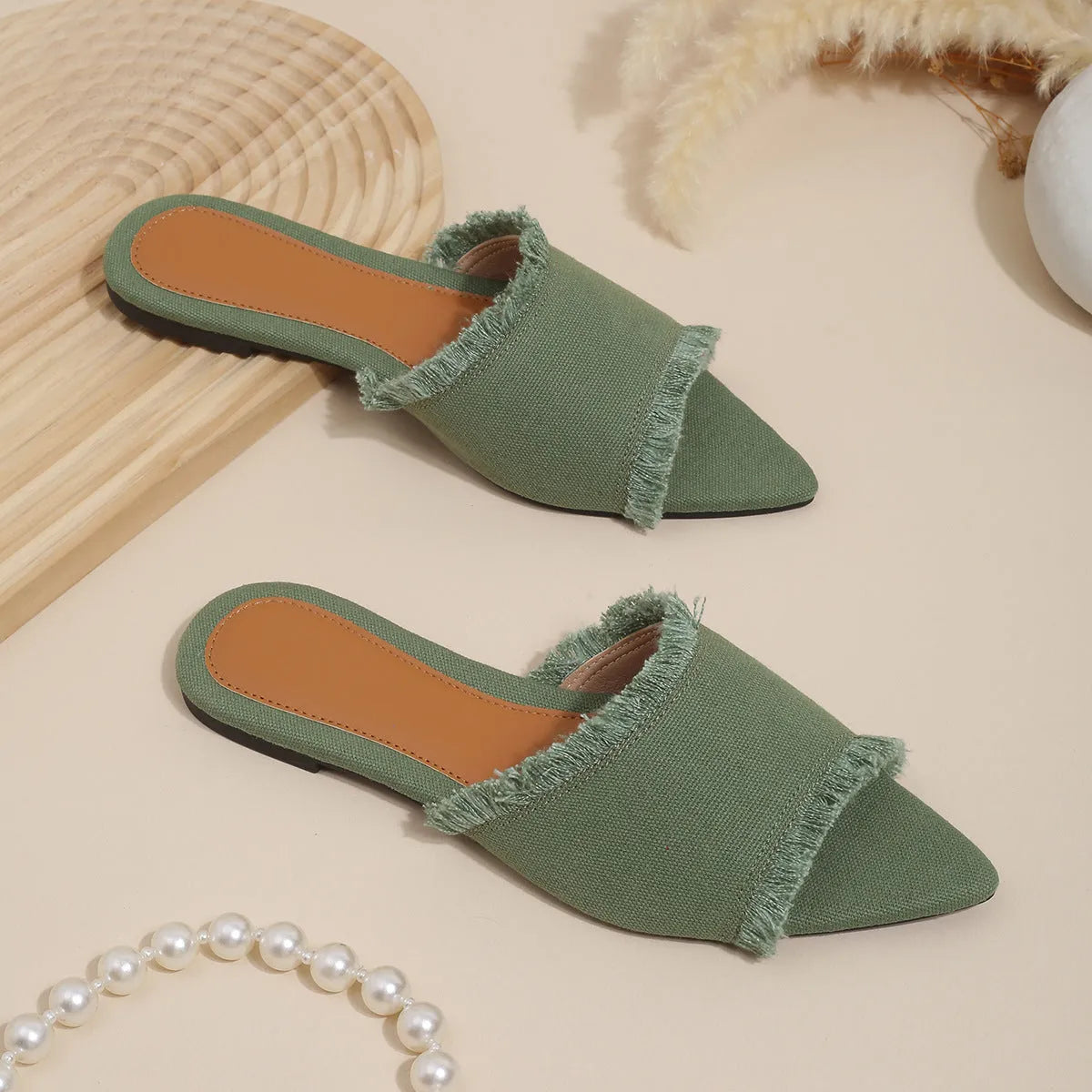 Women's denim flat slippers with tassel detail in apricot colour, showing leather lining.