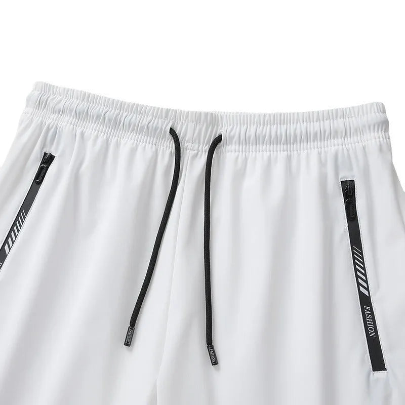 Man wearing black loose-fit quick-dry nylon sports shorts with an elastic waistband.