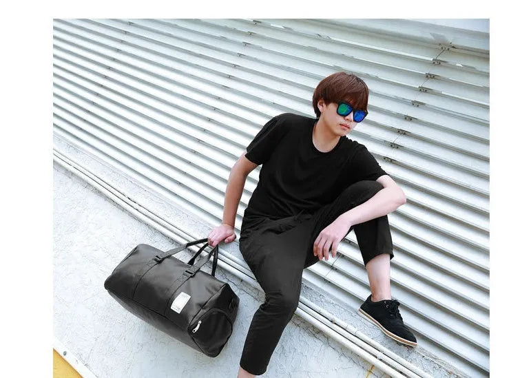 Black waterproof sports bag with separate shoe compartments on the sides, shown with adjustable diagonal strap.