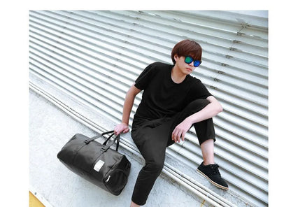 Black waterproof sports bag with separate shoe compartments on the sides, shown with adjustable diagonal strap.