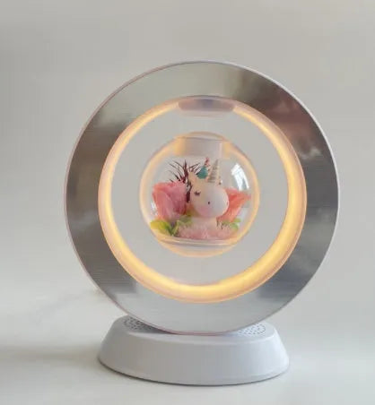 Pink rose eternal flower floating in magnetic levitation LED night light with triangular base and touch control