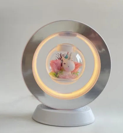 Pink rose eternal flower floating in magnetic levitation LED night light with triangular base and touch control