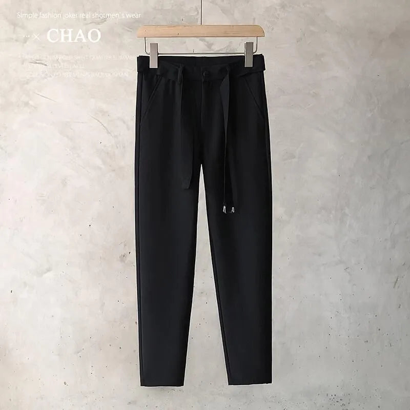 Boys slim straight wool trousers in tapered fit on hanger, showing straight leg opening.