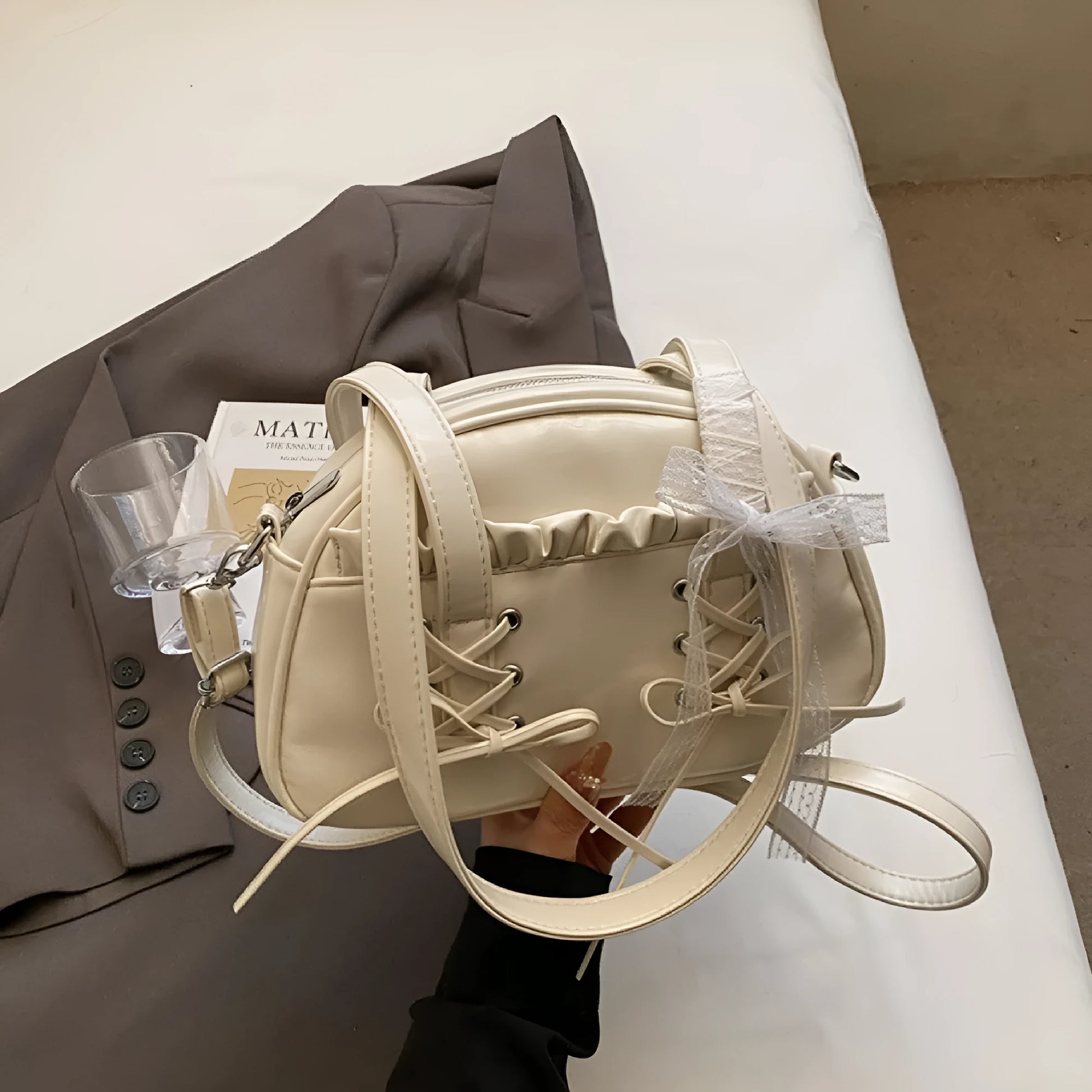 Women's PU leather casual shoulder handbag with a large bandage bow and sewing thread detail.