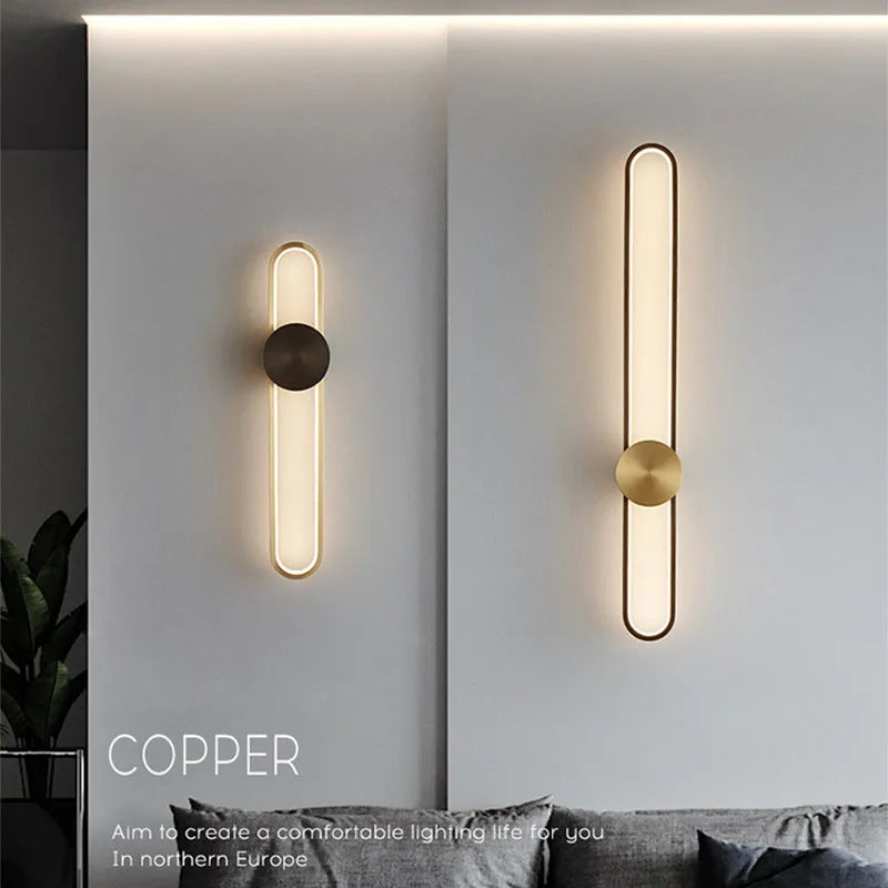 Modern round wall lamp with black iron shade and warm LED light, mounted on a grey wall.