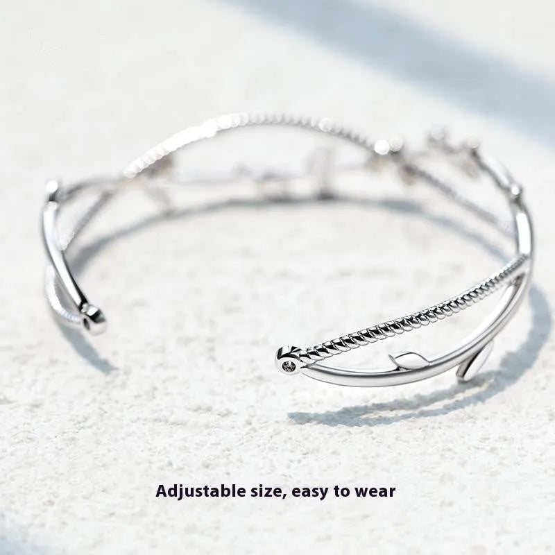 Copper ins style bracelet with detailed young tree branch and sprout cross twisted design in electroplated white gold colour.