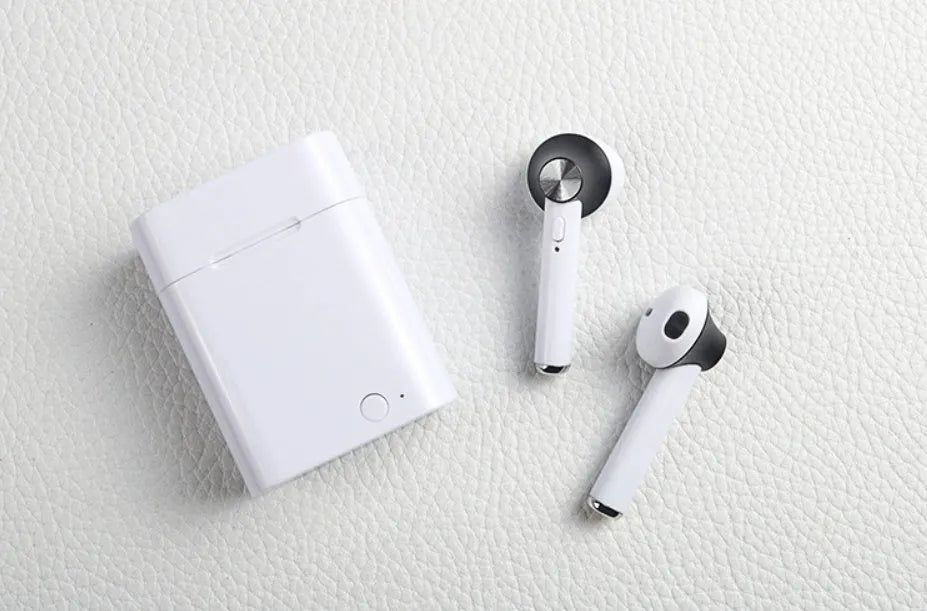 Black wireless sports Bluetooth earbuds showing battery display and placed next to a smartphone.