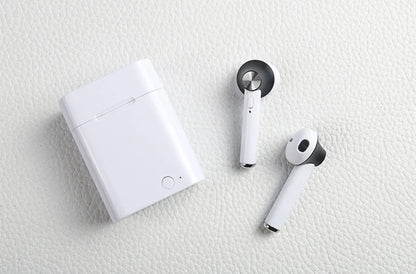 Black wireless sports Bluetooth earbuds showing battery display and placed next to a smartphone.