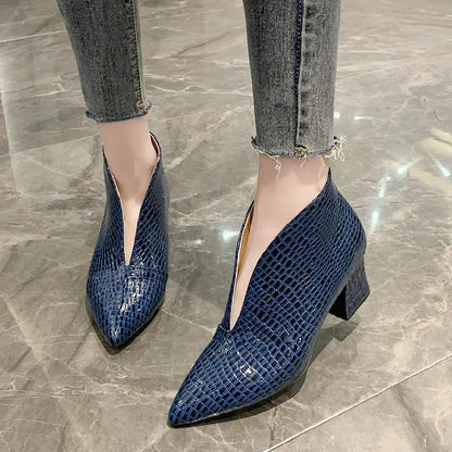 Women's black V cut Martin boots with a pointed embossed toe and a chunky heel.