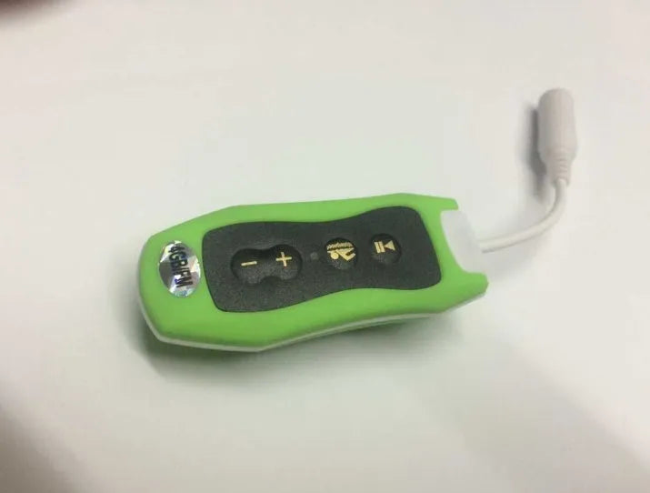 Compact black Bluetooth MP3 headset with clip, shown next to USB charging cable.