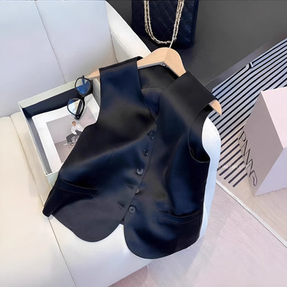 Black satin sleeveless vest on a hanger, showing loose fit and splicing detail.