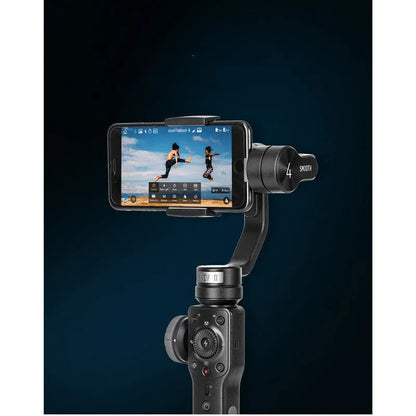 Black mobile phone handheld stabiliser gimbal on table with smartphone mounted