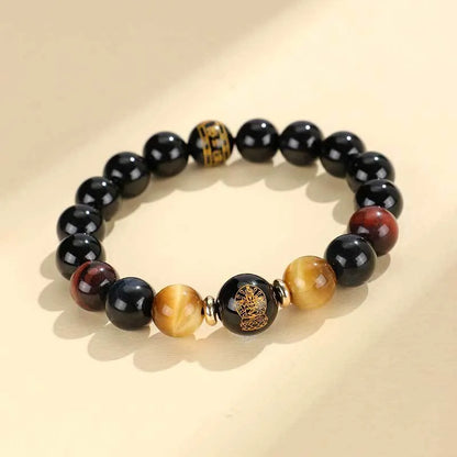 Handcrafted black agate and tiger eye stone beaded bracelet with a central carved zodiac deity charm.