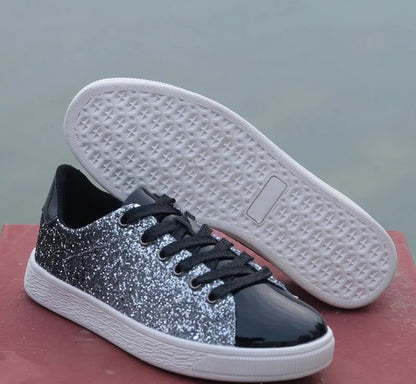 Women's low-top casual shoes with black sequin upper, round toe, and white rubber sole with lace-up closure.