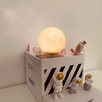 Maglev floating moon planet atmosphere night light with three astronaut figurines on a desk.