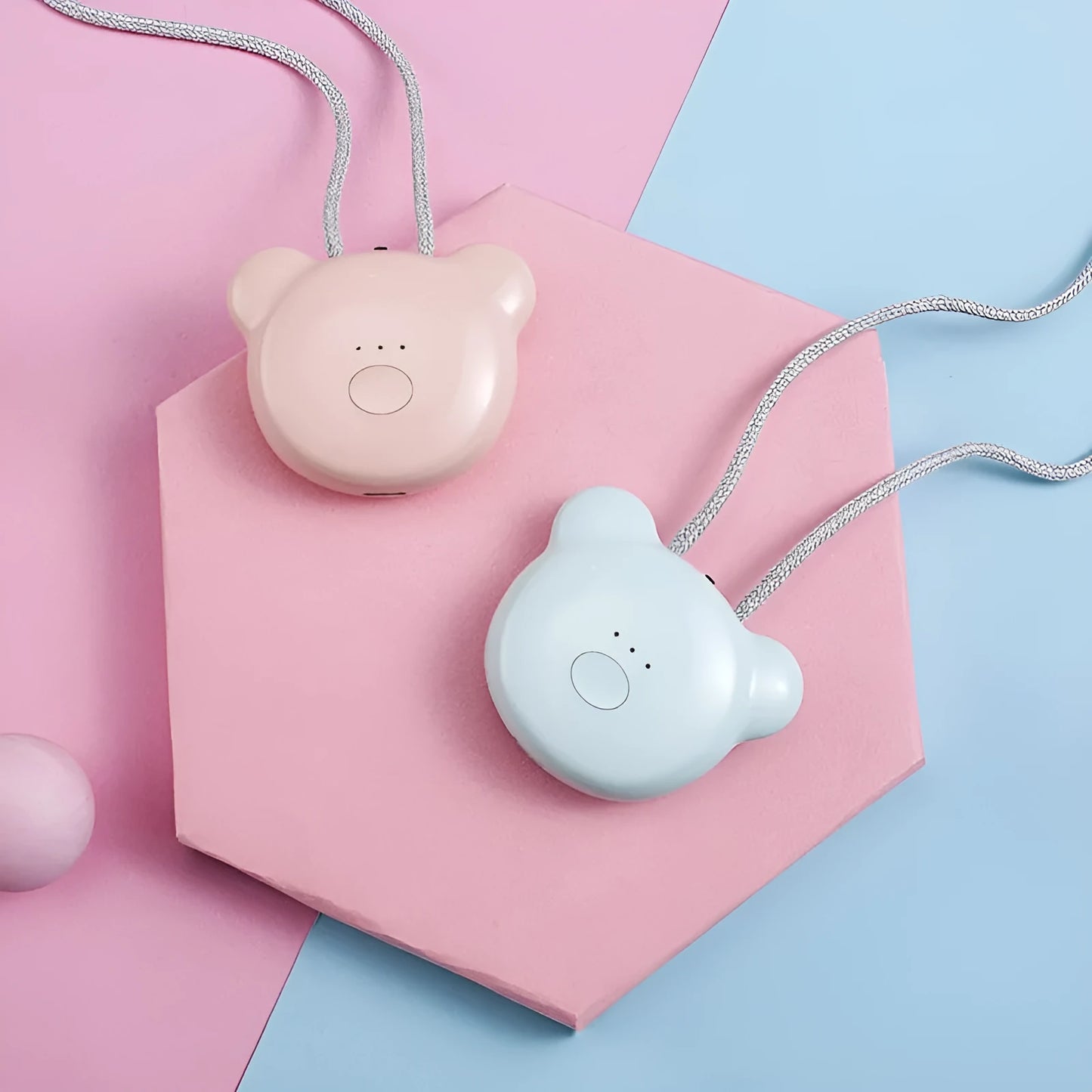 Small pink wearable air purifier pendant on a necklace, showing USB charging port and single button.