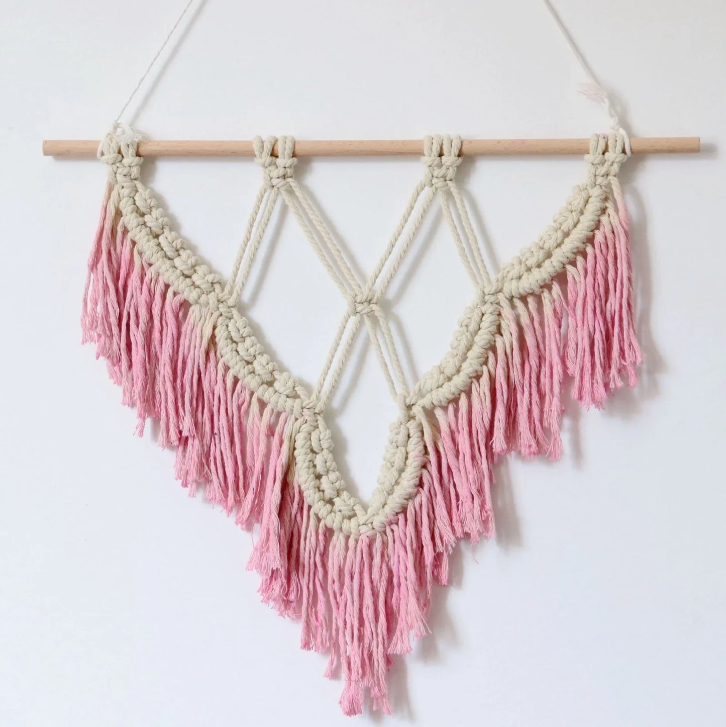 Handmade boho macrame wall hanging in pink cotton rope, 40cm high 50cm wide with wooden rod and natural seeds