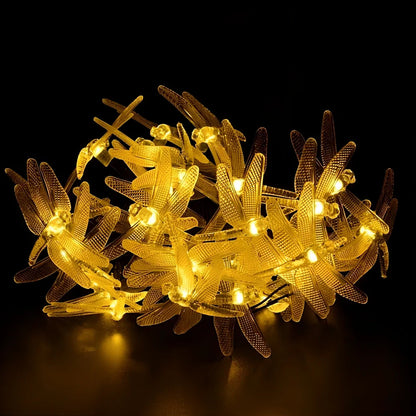 Solar-powered dragonfly string lights with 30 warm white LEDs in garden setting