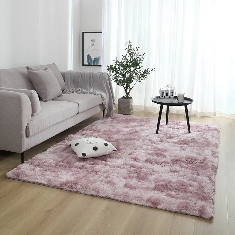 Soft fluffy plain rectangle carpet with anti-slip dots on backing, shown in a light grey colour on a wooden floor.