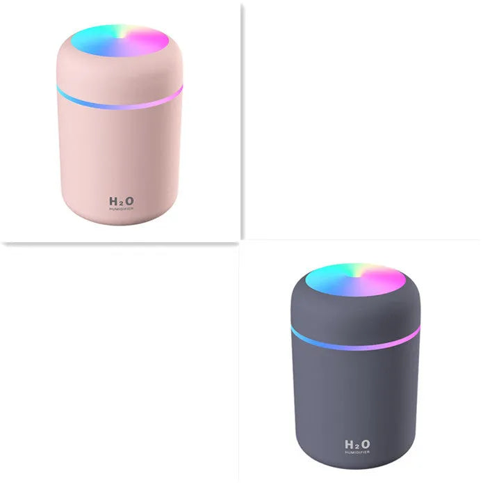 Pink USB desktop humidifier with LED lights and water tank on wooden desk