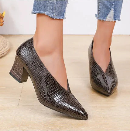 Women's black V cut Martin boots with a pointed embossed toe and a chunky heel.