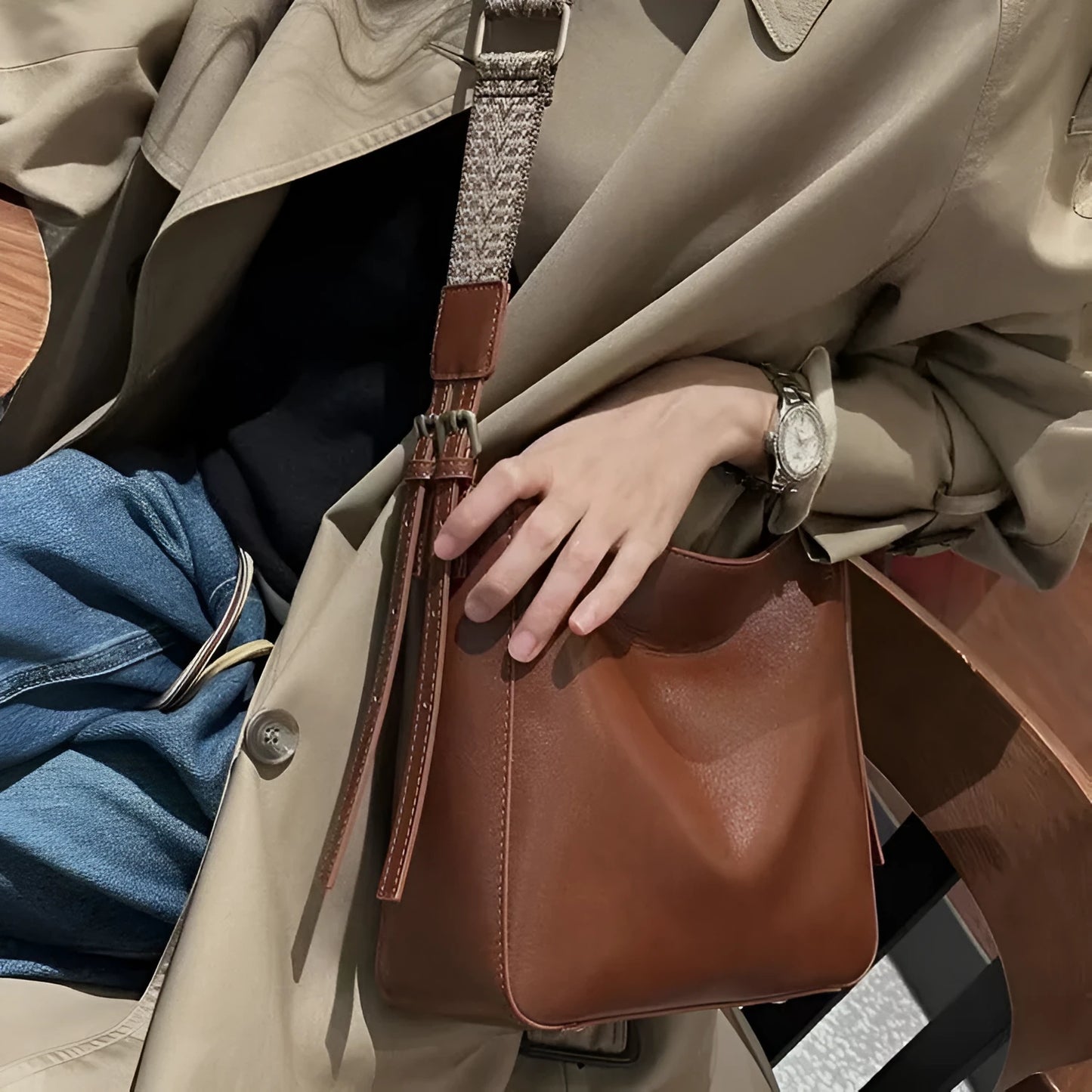 Women's black genuine leather shoulder messenger bag showing structured square shape and single strap.