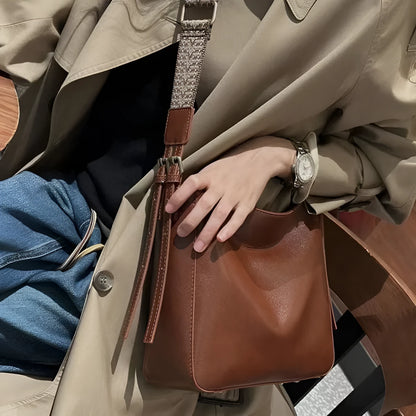 Women's black genuine leather shoulder messenger bag showing structured square shape and single strap.