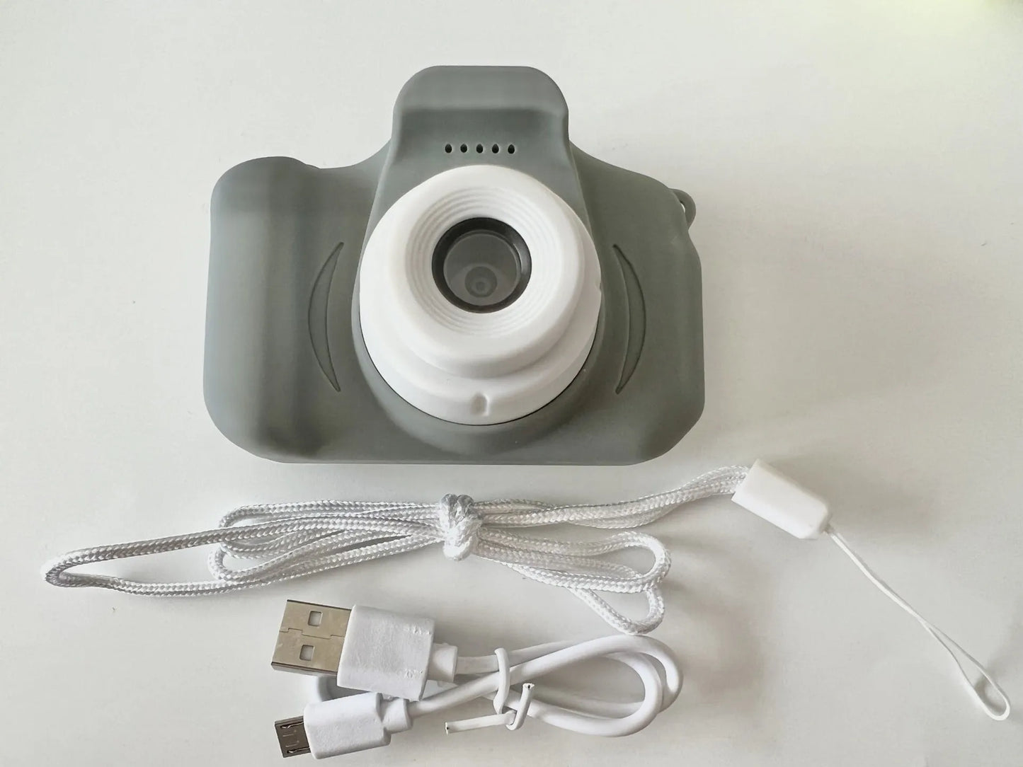 X2 HD mini digital camera for kids in silicone case with lanyard, shown capturing photo on 2-inch screen.