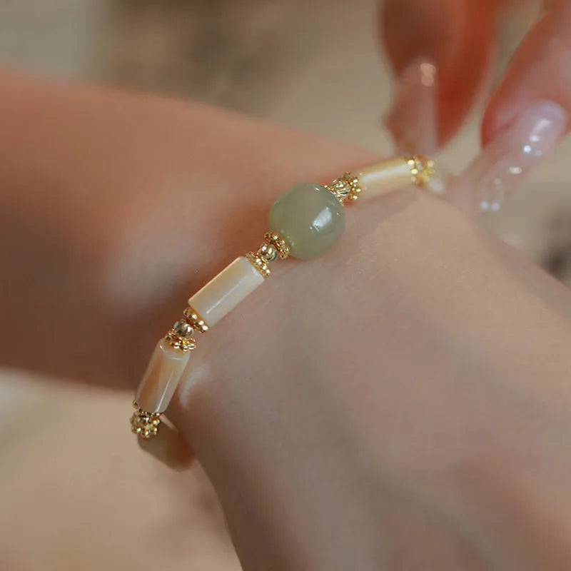 Hetian Jade white lip shell bracelet with geometric round beads on wrist