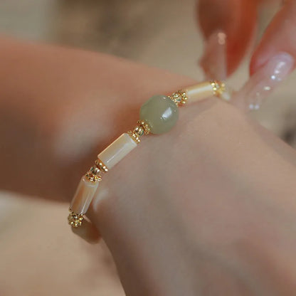 Hetian Jade white lip shell bracelet with geometric round beads on wrist