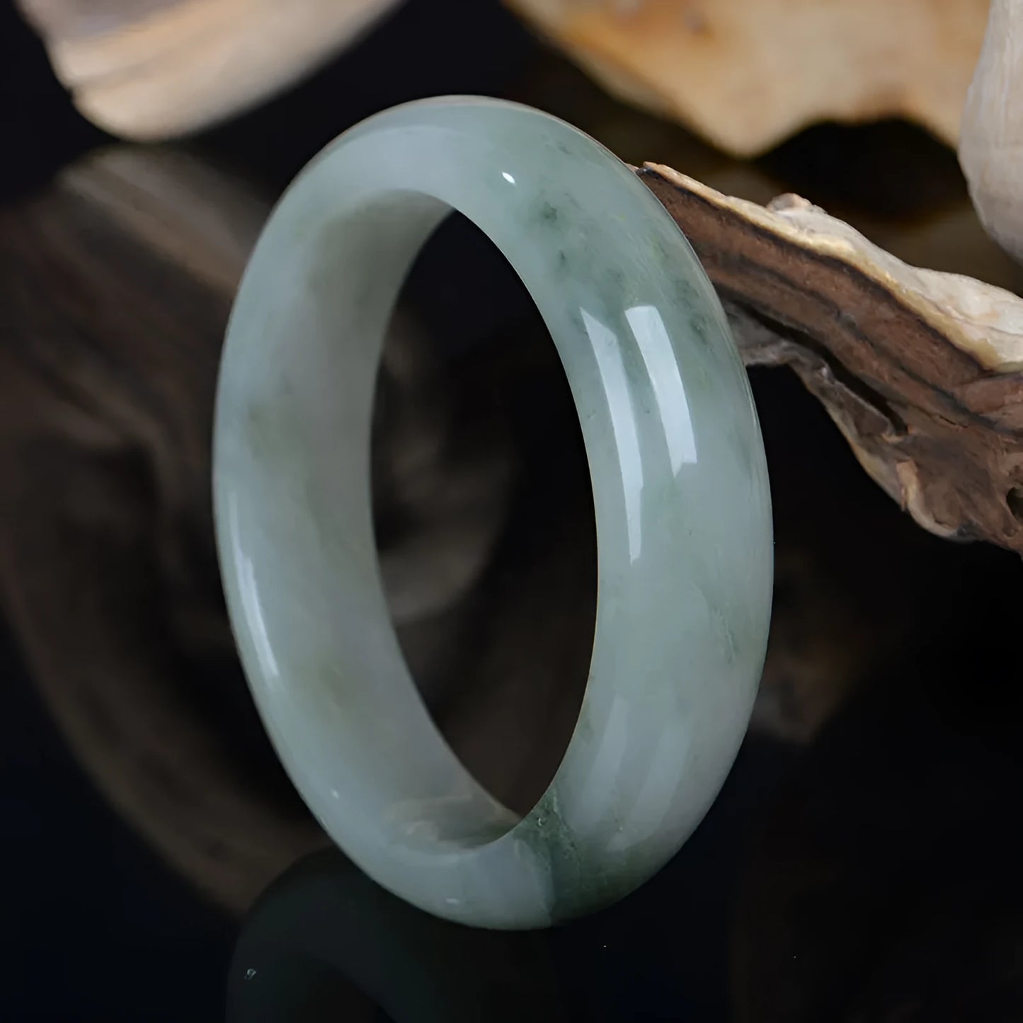 Natural Jinsi Jade Chinese bracelet in a closed bangle design on a plain background.