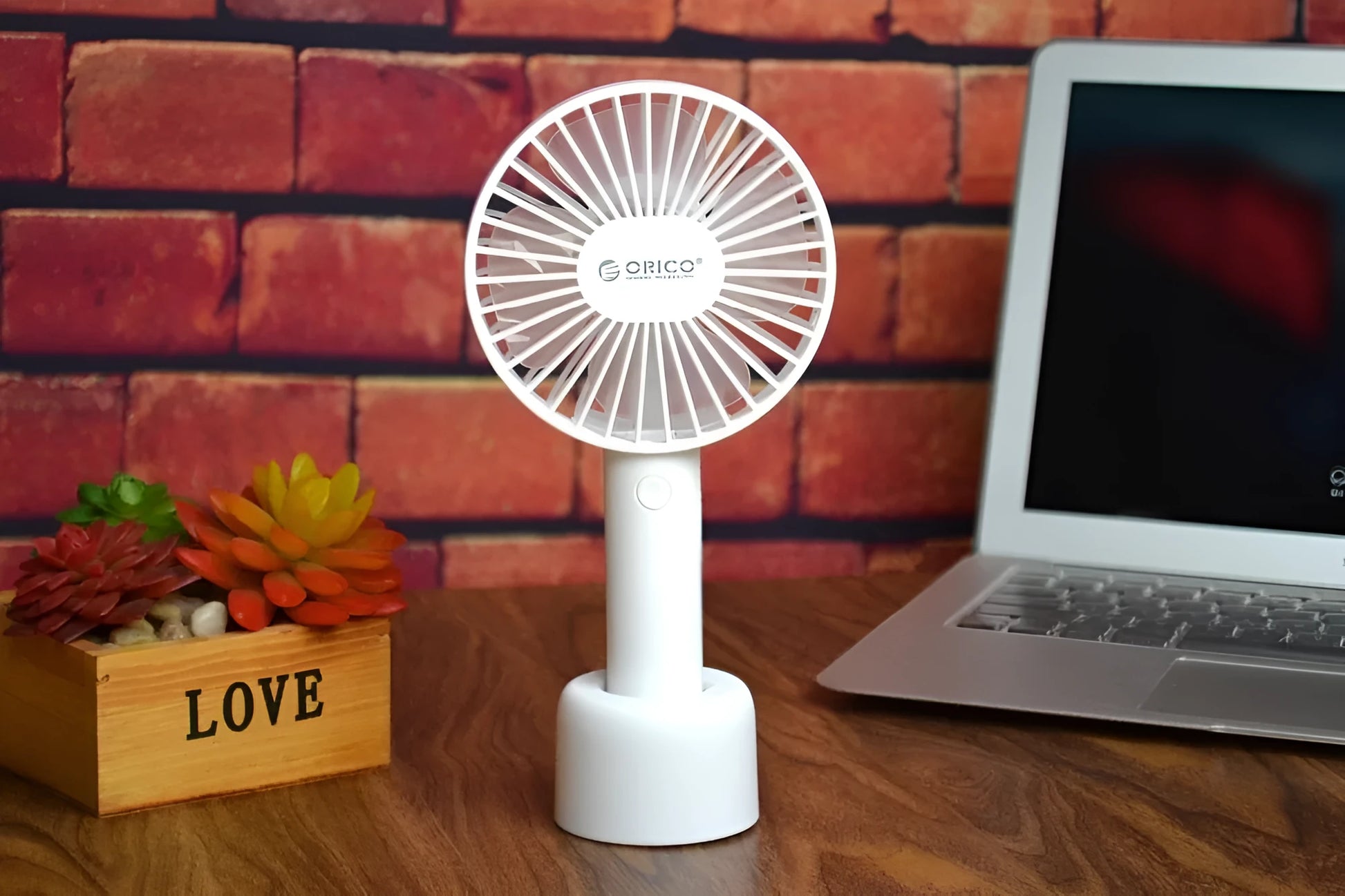 White ORICO FH1 portable USB rechargeable desk and handheld small fan with three speed buttons.