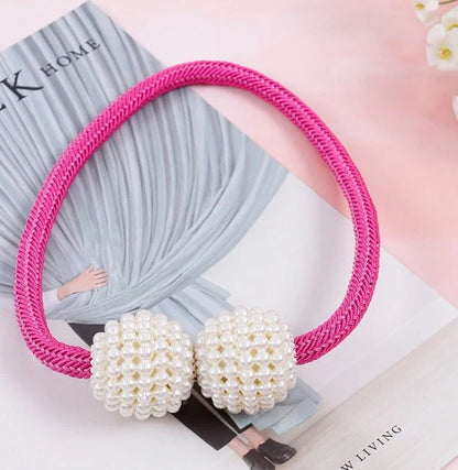 Magnetic curtain tiebacks with white pearl beads and fabric loops holding gathered curtain