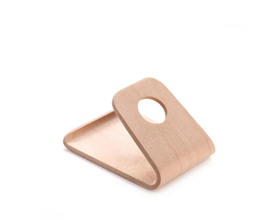 Solid wooden iPhone stand in Walnut finish on a desk, holding a mobile phone.