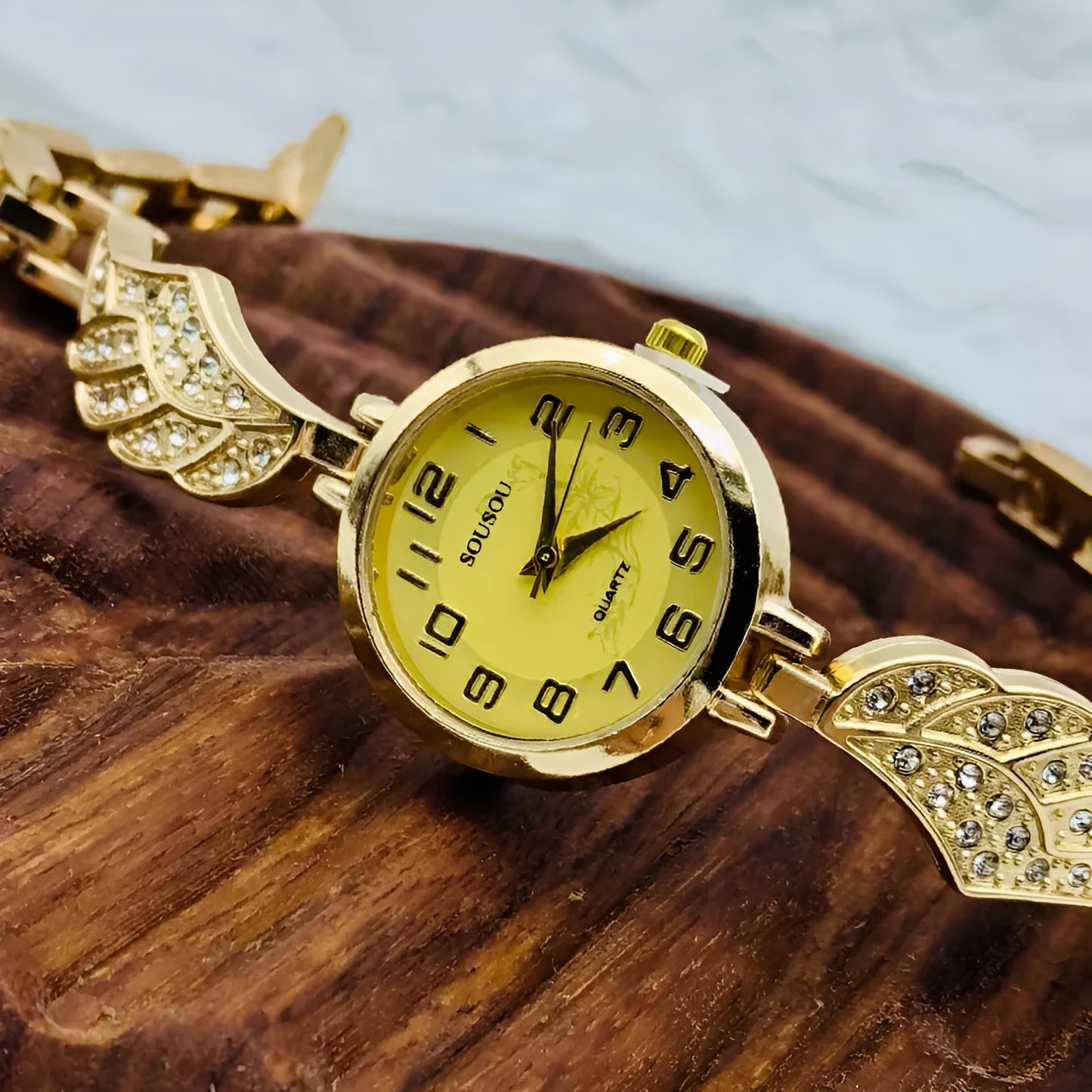Stainless steel women's watch with round dial and vachette clasp on wrist.