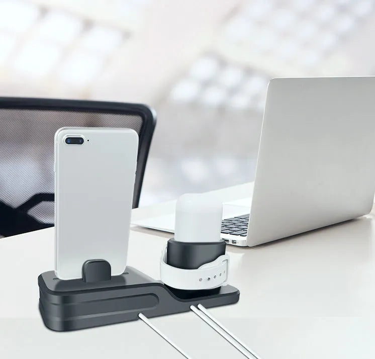 Black silicone 3-in-1 charging stand for Apple iPhone, Apple Watch, and AirPods on a desk