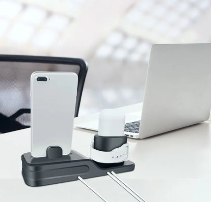 Black silicone 3-in-1 charging stand for Apple iPhone, Apple Watch, and AirPods on a desk