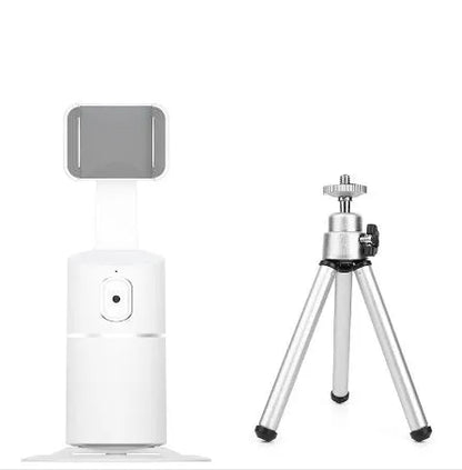 Black mini camera tripod with extended legs and a separate U-shaped universal phone clip on a table.
