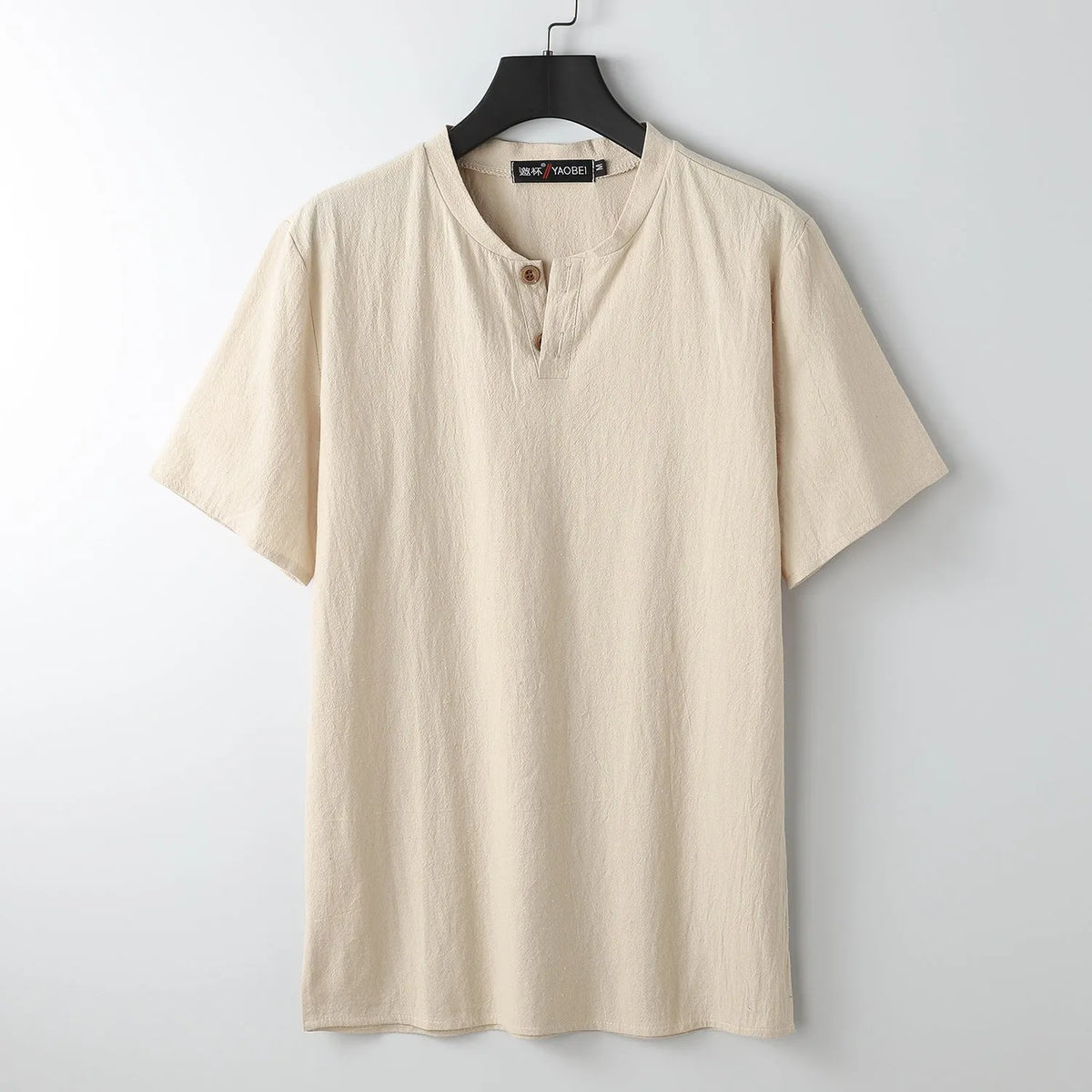 Women's loose fit apricot cotton V-neck short sleeve pullover top on a hanger.
