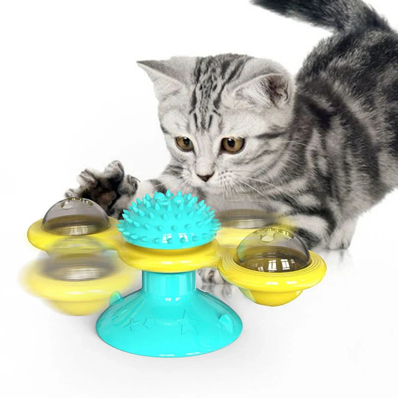 Cat playing with rotating windmill toy featuring luminous balls and suction base