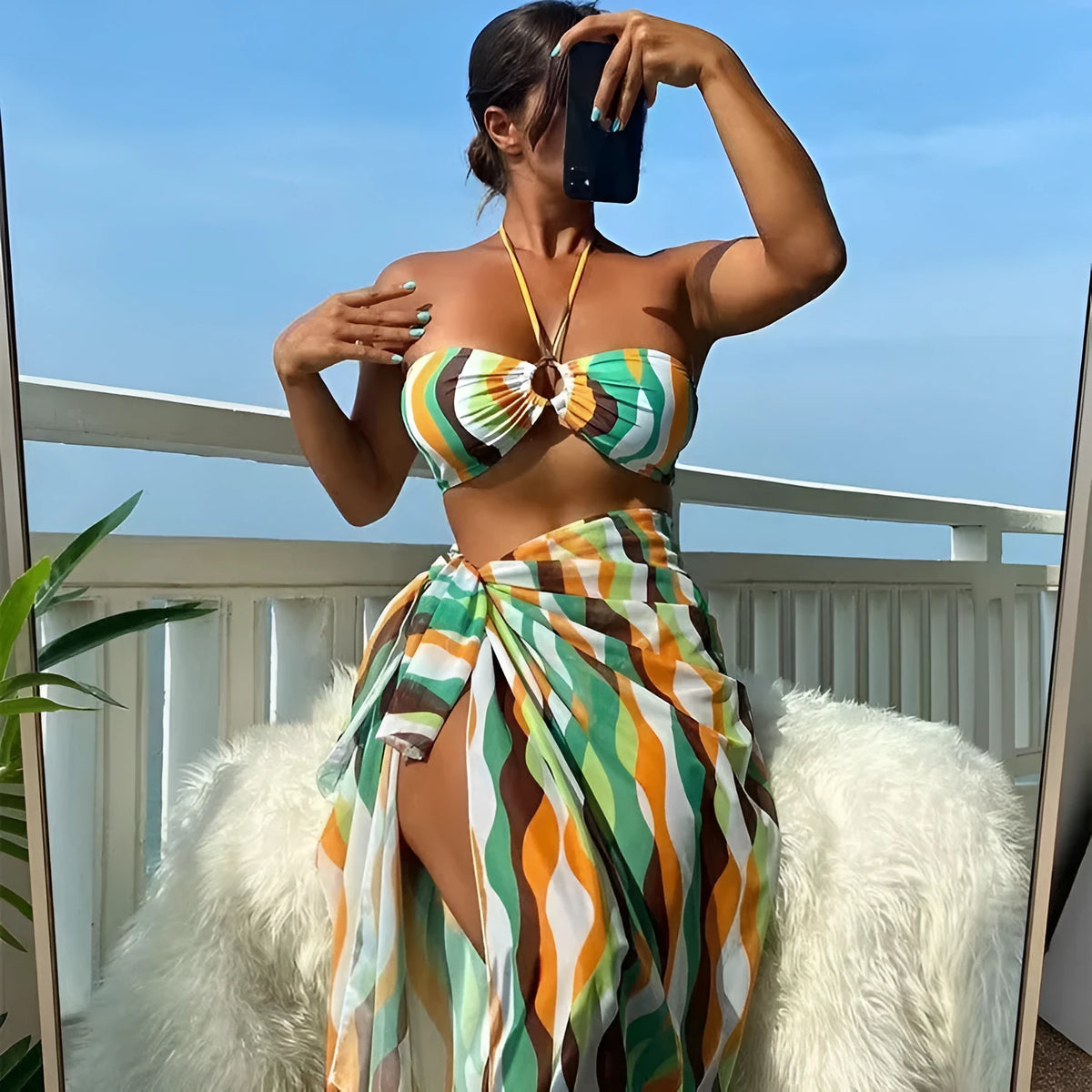 Women's three-piece swimwear set showing bikini top, briefs and printed beach skirt in polyester fabric