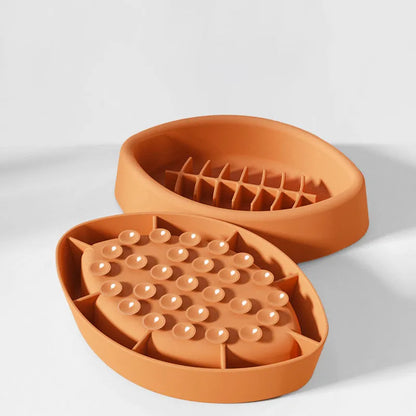 Blue silicone pet slow feeder bowl with textured interior and a white suction cup base on a wooden floor.