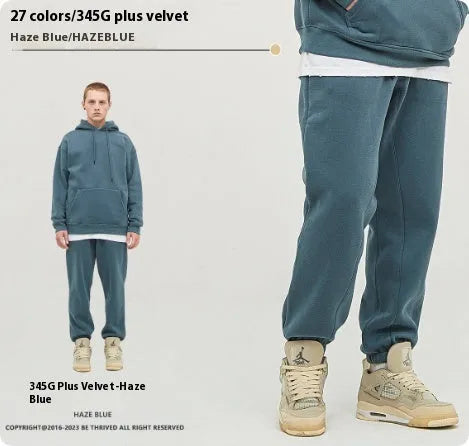 Man wearing solid colour cotton velvet sweatpants with an ankle banded design in a dark grey shade.