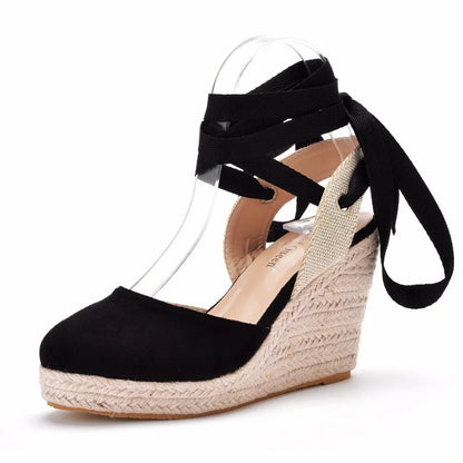 Women's red bohemian sandals with wedge heel, beaded strap, and adjustable ankle buckle on a wooden surface.