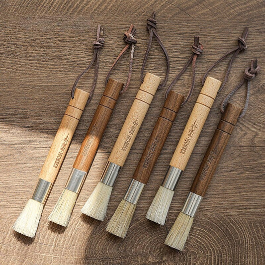 A natural fibre coffee grinder cleaning brush with a wooden handle, designed to safely remove coffee residue and maintain equipment performance.