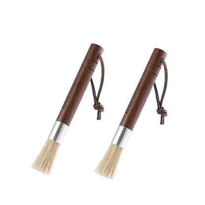 A natural fibre coffee grinder cleaning brush with a wooden handle, designed to safely remove coffee residue and maintain equipment performance.