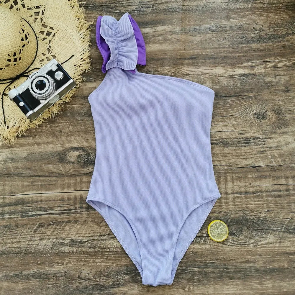Women's single-shoulder suspender tube top one-piece swimsuit in a high-waist design on a model.