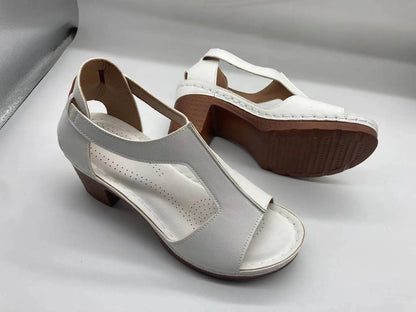 Women's beige peep toe wedge sandals with a buckle strap and low heel on a white background.